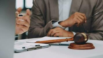 Justice and law concept.Male judge in a courtroom with the gavel, working with, computer and docking keyboard, eyeglasses, on table in morning light video