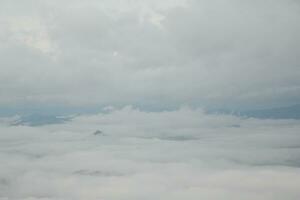 Mountain range with visible silhouettes through the morning blue fog. photo