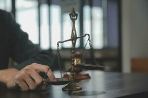 Business and lawyers discussing contract papers with brass scale on desk in office. Law, legal services, advice, justice and law concept picture with film grain effect photo