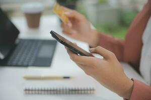 Women holding credit card and using smartphones at home.Online shopping, internet banking, store online, payment, spending money, e-commerce payment at the store, credit card, concept photo