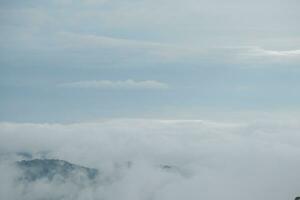 Mountain range with visible silhouettes through the morning blue fog. photo