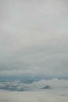 Mountain range with visible silhouettes through the morning blue fog. photo