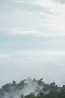 Mountain range with visible silhouettes through the morning blue fog. photo