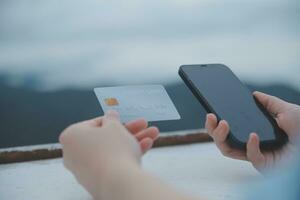 online payment, young woman holding credit card and typing on laptop photo