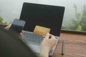 online payment, young woman holding credit card and touching on smartphone screen, copy space photo