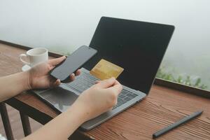 online payment, young woman holding credit card and touching on smartphone screen, copy space photo