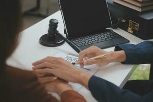 Business and lawyers discussing contract papers with brass scale on desk in office. Law, legal services, advice, justice and law concept picture with film grain effect photo