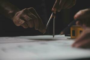 reunión de trabajo en equipo de ingenieros, trabajo de dibujo en la reunión de planos para el trabajo del proyecto con un socio en la construcción de modelos y herramientas de ingeniería en el concepto de sitio de trabajo, construcción y estructura. foto