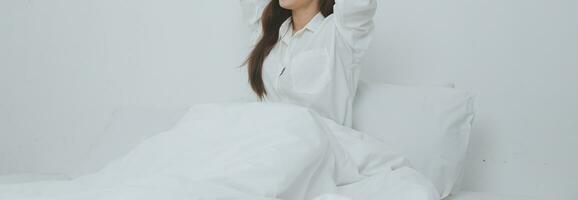 mujer estirándose en la cama después de despertarse foto