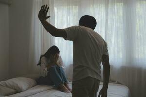 trastornado mujer teniendo un lucha con un hombre a hogar. Hispano esposa rápido el cara de su marido durante un argumento porque de su relación problemas foto