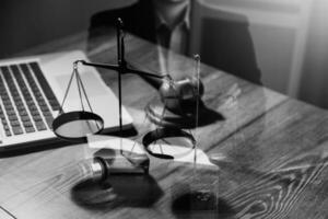 Justice and law concept.Male judge in a courtroom with the gavel, working with, computer and docking keyboard, eyeglasses, on table in morning light photo