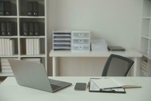 Asian Businesswoman Using laptop computer and working at office with calculator document on desk, doing planning analyzing the financial report, business plan investment, finance analysis concept. photo