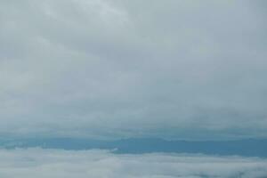 Mountain range with visible silhouettes through the morning blue fog. photo