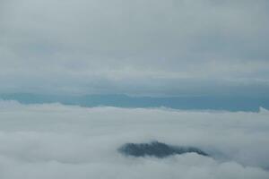 Mountain range with visible silhouettes through the morning blue fog. photo