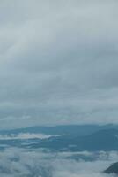 Mountain range with visible silhouettes through the morning blue fog. photo