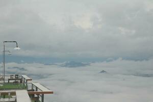 Mountain range with visible silhouettes through the morning blue fog. photo