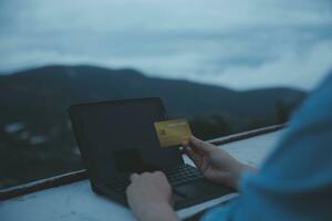 online payment, young woman holding credit card and typing on laptop photo