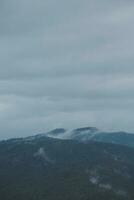 Mountain range with visible silhouettes through the morning blue fog. photo