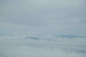 Mountain range with visible silhouettes through the morning blue fog. photo