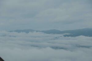 Mountain range with visible silhouettes through the morning blue fog. photo