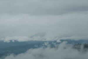 Beautiful panoramic view of fog and clouds in distant layers mountains range with blue sky in morning photo