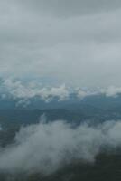 Beautiful panoramic view of fog and clouds in distant layers mountains range with blue sky in morning photo