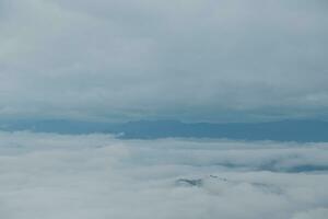 Mountain range with visible silhouettes through the morning blue fog. photo