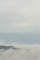 Mountain range with visible silhouettes through the morning blue fog. photo