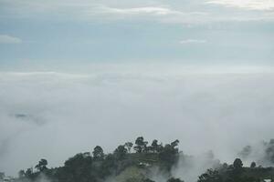 Mountain range with visible silhouettes through the morning blue fog. photo