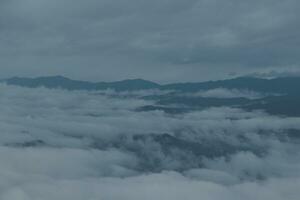 Mountain range with visible silhouettes through the morning blue fog. photo