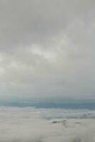 Mountain range with visible silhouettes through the morning blue fog. photo