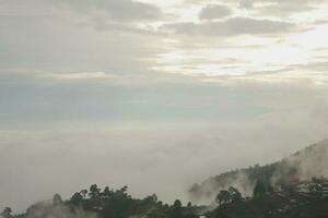 Mountain range with visible silhouettes through the morning blue fog. photo