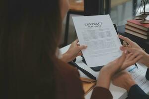 Business and lawyers discussing contract papers with brass scale on desk in office. Law, legal services, advice, justice and law concept picture with film grain effect photo