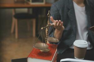 Business and lawyers discussing contract papers with brass scale on desk in office. Law, legal services, advice, justice and law concept picture with film grain effect photo