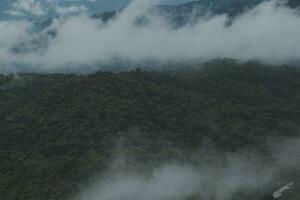 Beautiful panoramic view of fog and clouds in distant layers mountains range with blue sky in morning photo