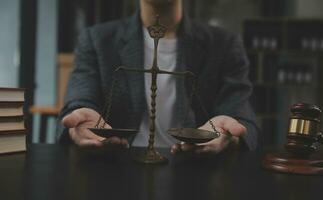 Business and lawyers discussing contract papers with brass scale on desk in office. Law, legal services, advice, justice and law concept picture with film grain effect photo