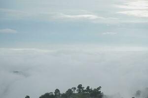 Mountain range with visible silhouettes through the morning blue fog. photo