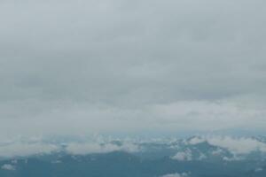 Beautiful panoramic view of fog and clouds in distant layers mountains range with blue sky in morning photo