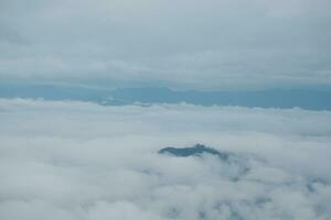 Mountain range with visible silhouettes through the morning blue fog. photo