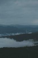 montaña rango con visible siluetas mediante el Mañana azul niebla. foto