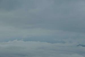 Mountain range with visible silhouettes through the morning blue fog. photo