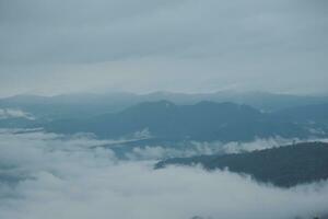 montaña rango con visible siluetas mediante el Mañana azul niebla. foto