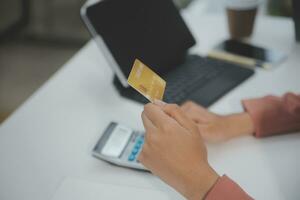 mujer participación crédito tarjeta y utilizando teléfonos inteligentes a casa.online compras, Internet bancario, Tienda en línea, pago, gasto dinero, comercio electrónico pago a el almacenar, crédito tarjeta, concepto foto