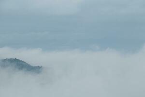 Mountain range with visible silhouettes through the morning blue fog. photo