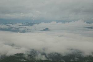 Mountain range with visible silhouettes through the morning blue fog. photo