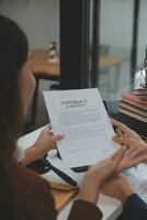 Business and lawyers discussing contract papers with brass scale on desk in office. Law, legal services, advice, justice and law concept picture with film grain effect photo