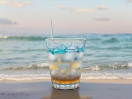 Cold drink in galss cup with beach ocean background, photo
