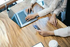 Woman holding credit card and using laptop computer. Online shopping concept. photo