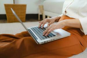 Working by using a laptop computer on wooden table. Hands typing on a keyboard.technology e-commerce concept photo