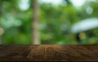 Empty wood table top and blur of out door garden background Empty wooden table space for text marketing promotion. blank wood table copy space for background photo